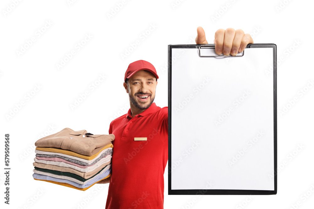 Wall mural Laundry worker holding a pile of folded clothes and showing a blank document