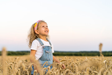 a little blonde curly girl running in a wheat field, the concept of human freedom