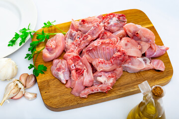 Raw rabbit meat with spices and herbs on wooden cutting board