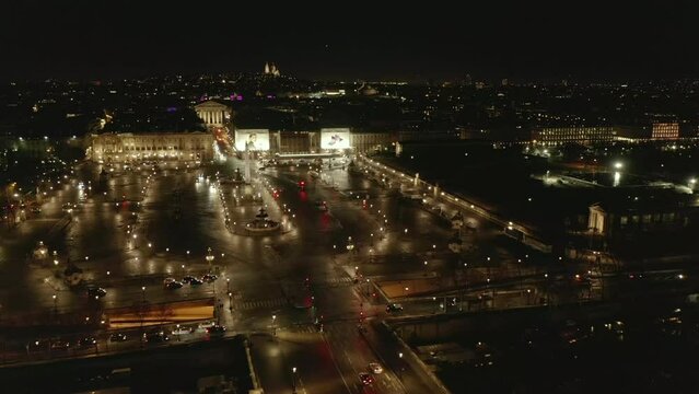 Aerial view of Place de la Concorde with Luxor Obelisk. Vehicles passing illuminated square in late evening. Paris, France
