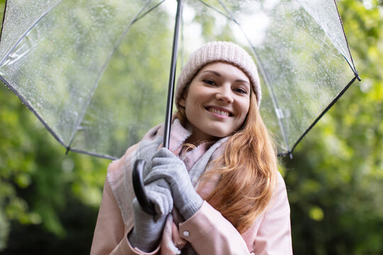 portrait of beautiful young girl walking with umbrella under rain