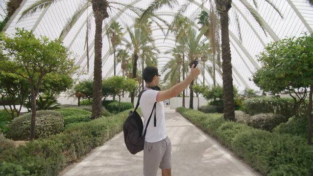 Caucasian student recording video for his vlog about traveling. Successful blogger using his smartphone and broadcasting online. High quality 4k footage