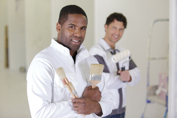 painter with apprentice holding brush and roll