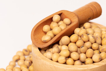 Close up Yellow Soy Bean in wooden bowl, Golden Soybean turn process to cooking oil, soy bean is healthy diet and food element cooking ingredients. White background isolated