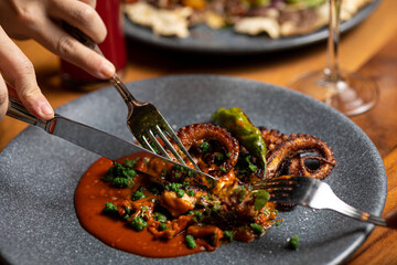 People sharing a grilled octopus dish