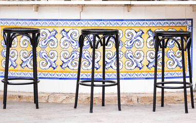 bar chairs in front of colorful spanish tiles