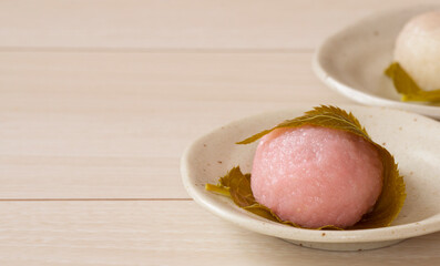Japanese sweets in spring. Sakura mochi on white table. 春の和菓子。白いテーブルの上の桜餅