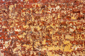 Wall with layers of scraped red, yellow and white paint