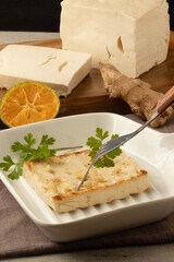 Tasting grilled tofu with ginger.
