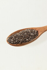 Chia seeds on wooden spoon isolated on white background.