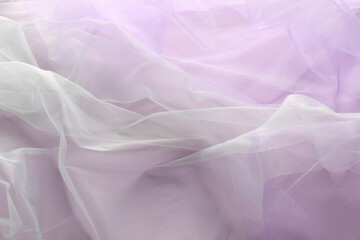 Beautiful tulle fabric on lilac background, top view