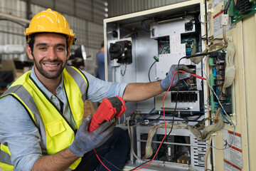 Male electrician worker checking, repair, maintenance operation electric system in factory. Male electrician using electrical meters working with operation electric system in workshop