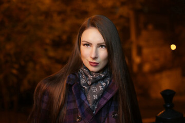 beautiful girl, in the evening at night in the city on the street, cool, cold, with a round natural face, fashion, autumn