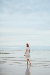Fototapeta na wymiar woman walking on the beach 제주도 협제 해수욕장