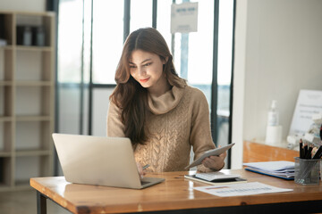 Fototapeta na wymiar Young Asian businesswoman holding notebook about business, spending money