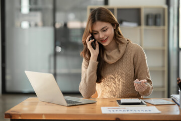 Young Asian businesswoman holding notebook about business, spending money