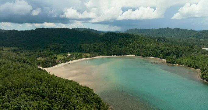 A bay with a beautiful beach among tropical vegetation. Loro Kecil beach. Borneo, Malaysia.