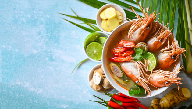 Shrimp soup on seafood soup bowl with thai herb and spices, Hot and sour spicy shrimps prawns soup  curry lemon lime galangal red chili straw mushroom on table food, Thai Food Tom Yum Kung