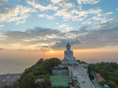 aerial view Phuket big Buddha in beautiful sunset..the sun shines through the clouds impact on ocean surface.The beauty of the statue fits perfectly with the charming nature..cloud scape background..