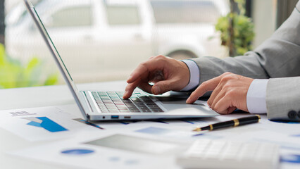 Businessman typing on laptop keyboard working on home finance related to taxes and expenses