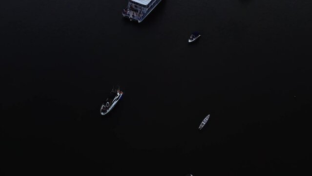 Tilt up aerial shot of a small group of tour boats watching the famous sunset at the alligator beach, a large river in Cabedelo, Paraiba, Brazil, near the coastal capital city of Joao Pessoa