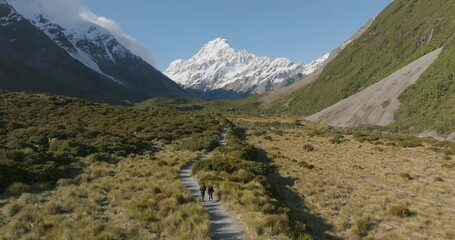 Couple enjoying sunny day in Hooker valley with distant snowy mountain