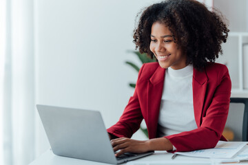 happy young businesswoman African American siting on the chiar cheerful demeanor raise holding coffee cup smiling looking laptop screen.Making opportunities female working successful in the office.
 - Powered by Adobe