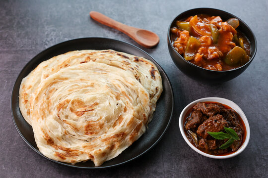 Kerala parathas porotta roti parotta barotta naan layered flatbread made from maida or whole wheat flour. Eat with spicy Asian chicken chili chicken beef curry gravy. breakfast dish. Indian food.