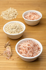 White bowls with coarse Himalayan salt and oats.