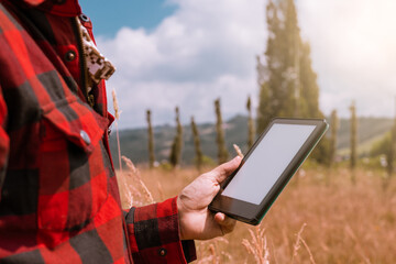 Digital Farming: Farmer Checking Crops on Tablet in Sunny Field