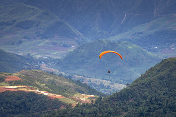 Parachute jumpers perform during the Paragliding festival. The annual paragliding festival is held in Mu Cang Chai, Vietnam