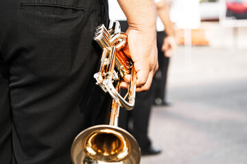 hands of person holding a trumpet. music and marching band concept.