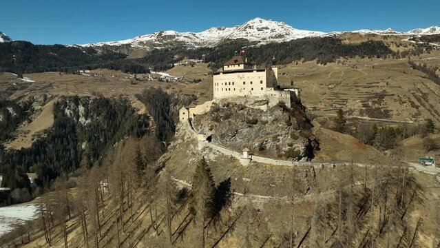 Schloss Tarasp on a sunny day in winter time in Switserland. Drone panning shot
