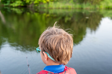 Boy on a fishing with blue water in background