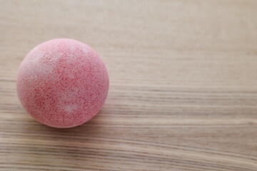 Bath bomb on light wooden table