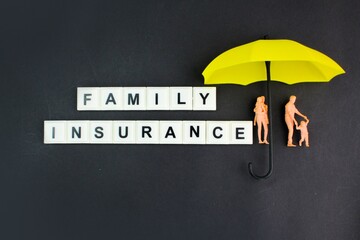 the family is covered by a yellow umbrella with the words family insurance. the concept of family protection