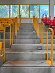 View of concrete steps with railings and seats in stadium