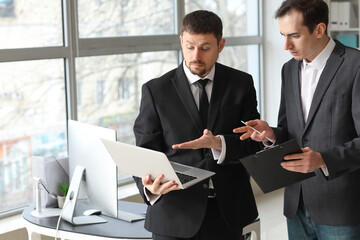Male accountant working with his colleague in office