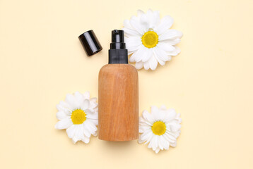 Obraz na płótnie Canvas Bottle pf cosmetic product with chamomile flowers on color background