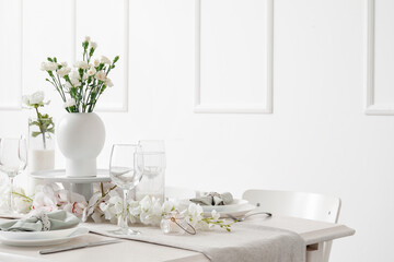 Beautiful table setting for International Women's Day celebration with eustoma and orchid flowers in light room