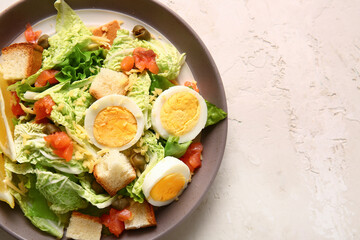 Plate of delicious salad with boiled eggs and salmon on white grunge background