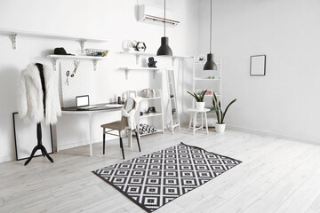 Fototapeta premium Interior of modern atelier with tailor's workplace, shelving units and mirror