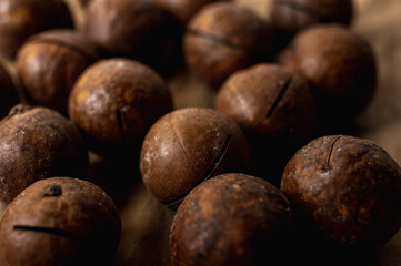 background, macadamia nuts close up view on gray background, tasty nut healthy food. Low key