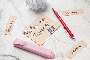 Papers with French words, pens and crumpled paper on grunge background