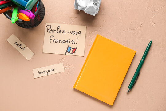 Papers with French words and stationery on beige background