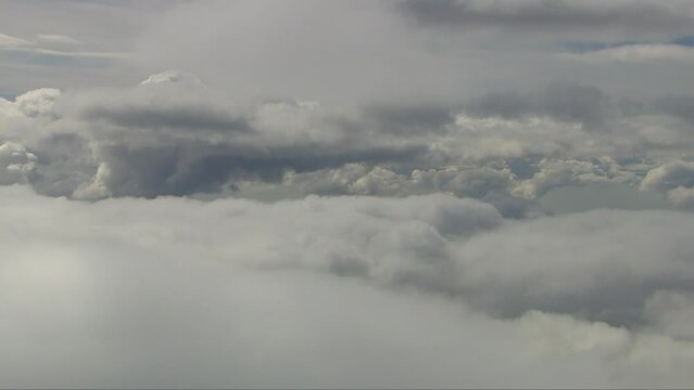 Aerial shot in between white fluffy clouds with clouds above and below