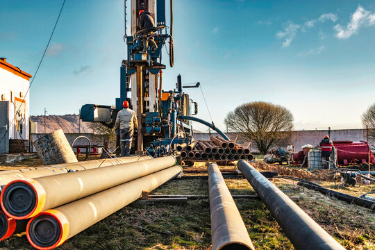 The Drilling Rig Close-up Is Drilling A Well Against The Background Of The Cloudy Sky. Deep Hole Drilling. Geological Exploration Work. Mineral Exploration. Extraction Of Gas And Oil.