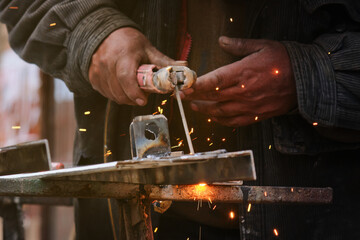 Solid Headlines: Latino Man Welding Metal Leads Innovation in the Industry