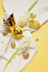 Beautiful hyacinth flowers, Easter eggs and bunny on yellow background