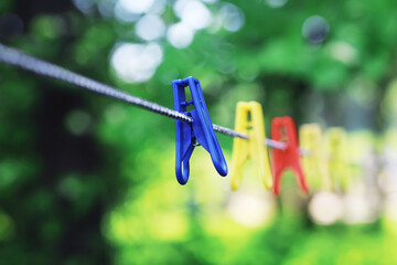 Dry clothes outside. Clothes on a rope. Clothespins on a clothesline in summer.